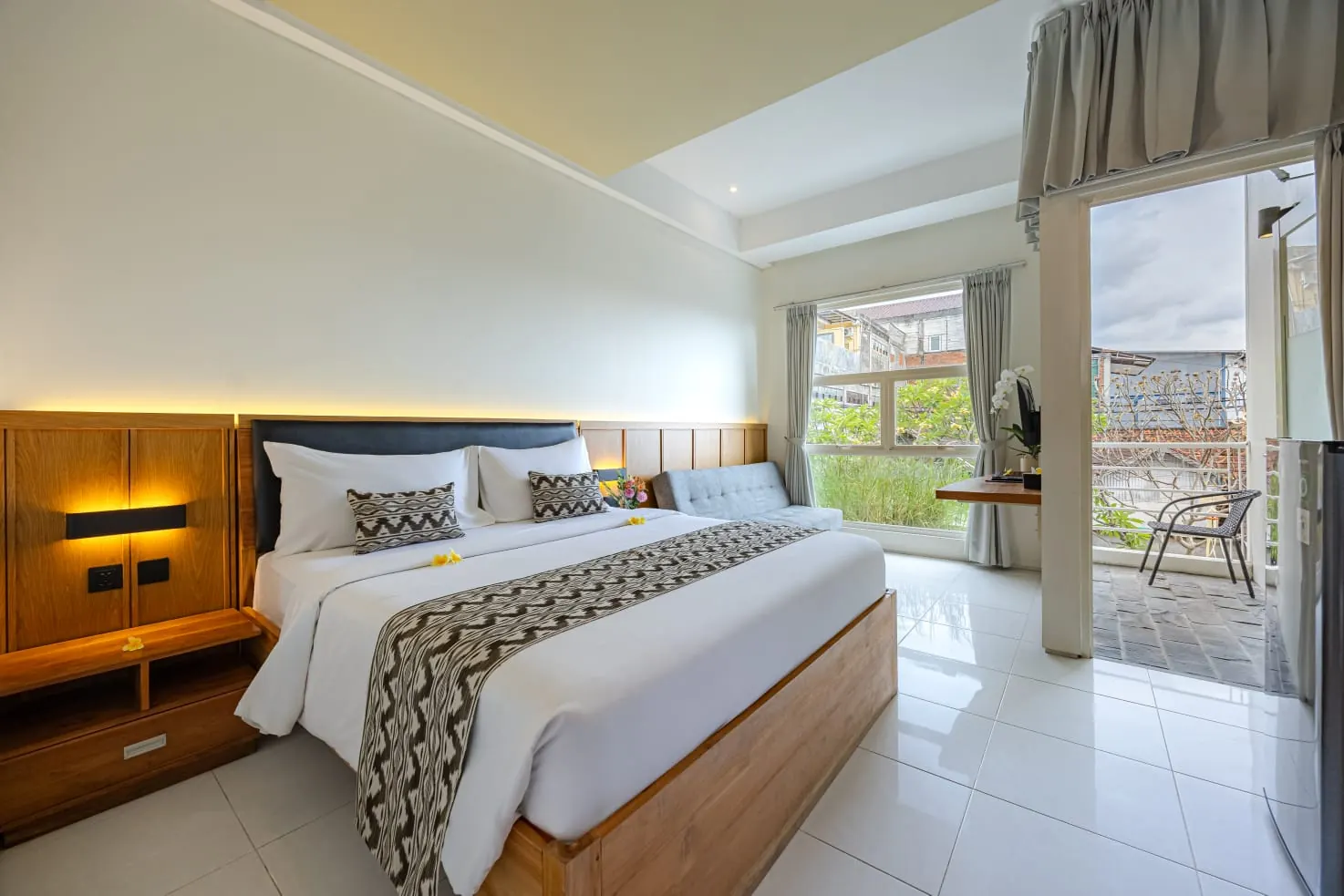 Executive Suite bedroom with tall windows and access to the balcony